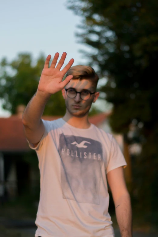 a young man in glasses tossing a frisbee