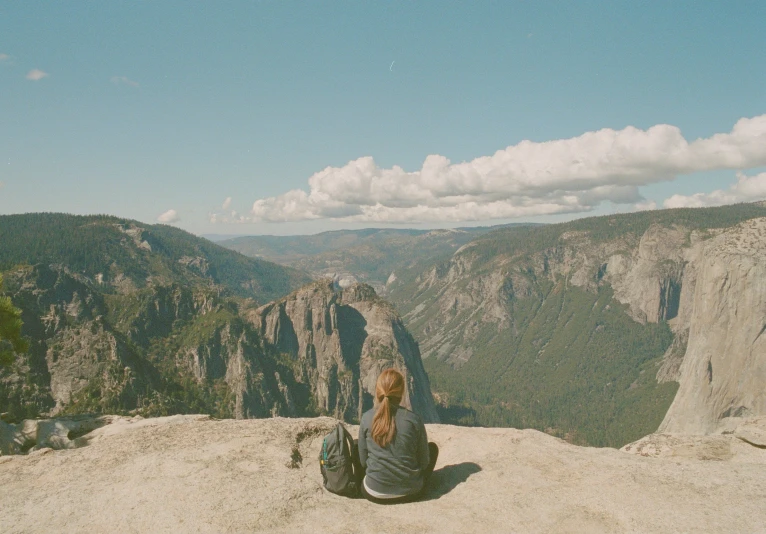 a woman on top of a mountain looking over the valley