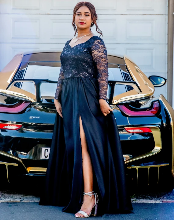 a woman stands next to a sports car