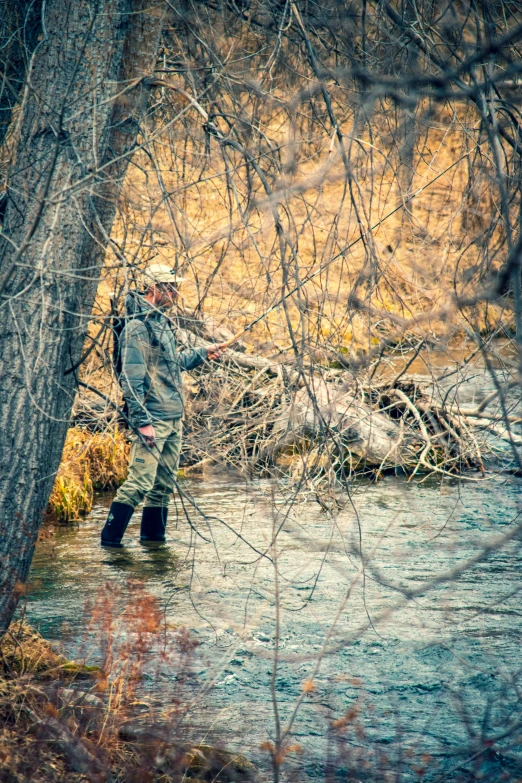 a man standing in the water holding a fishing pole