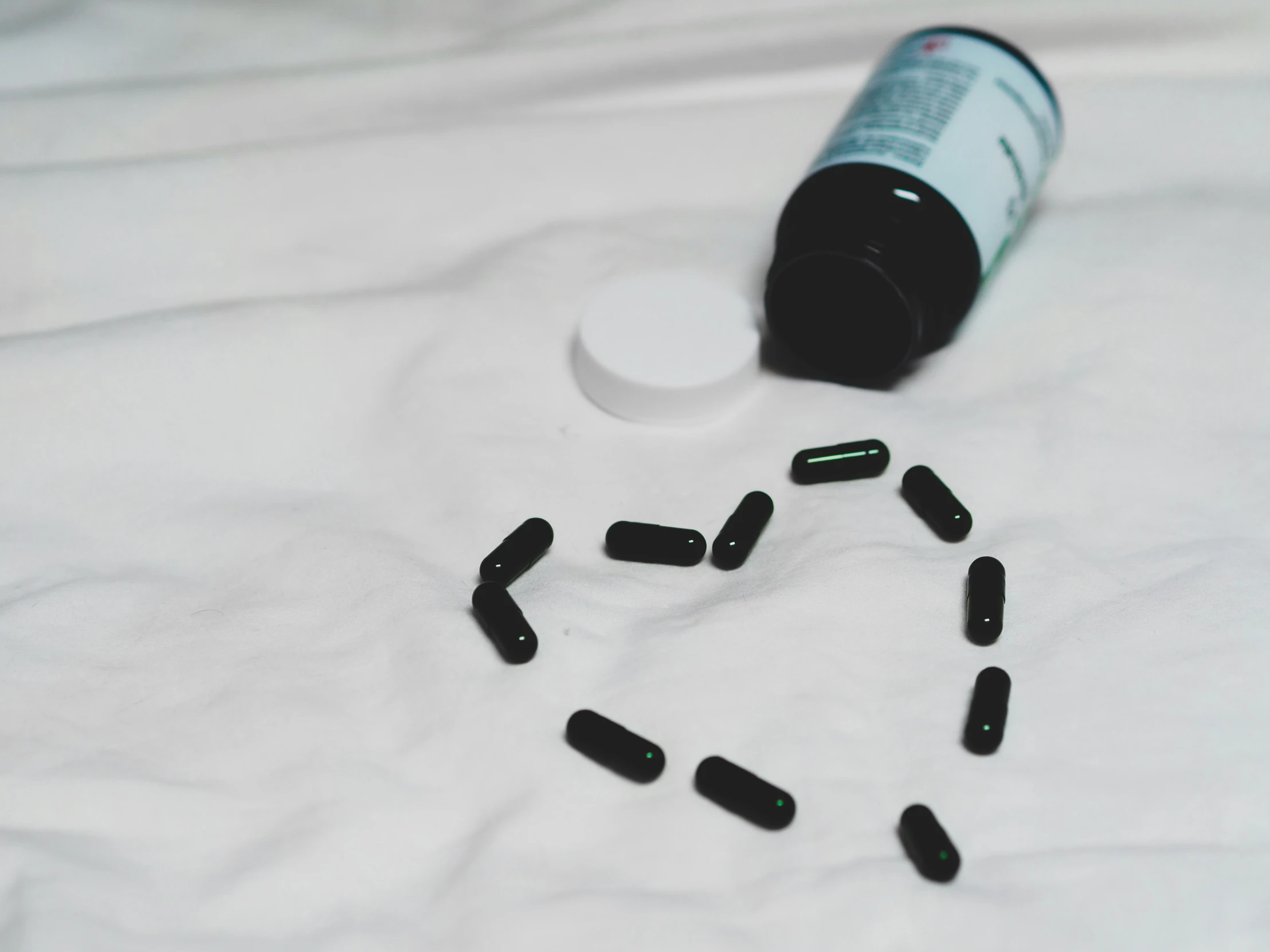 one small medicine bottle laying on a bed of pills