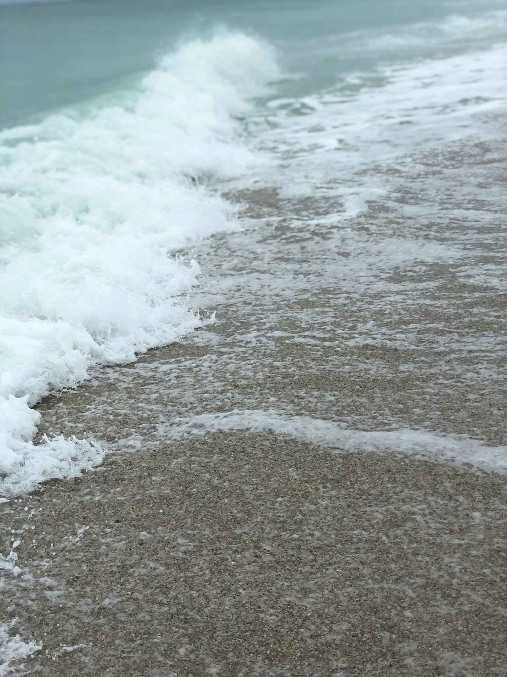 the tide lapes into the beach shore and is moving away