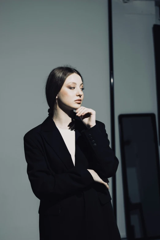 a beautiful young lady posing with her hand on her mouth