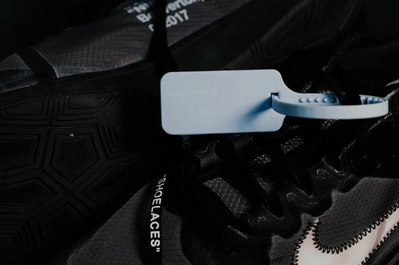 a white tag attached to a black shoe