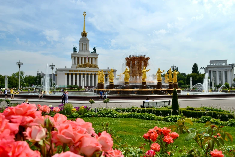 a fountain and flowers near the side of the road