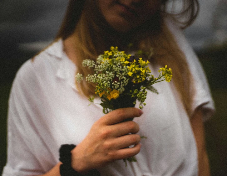 woman holding small flowers standing by herself
