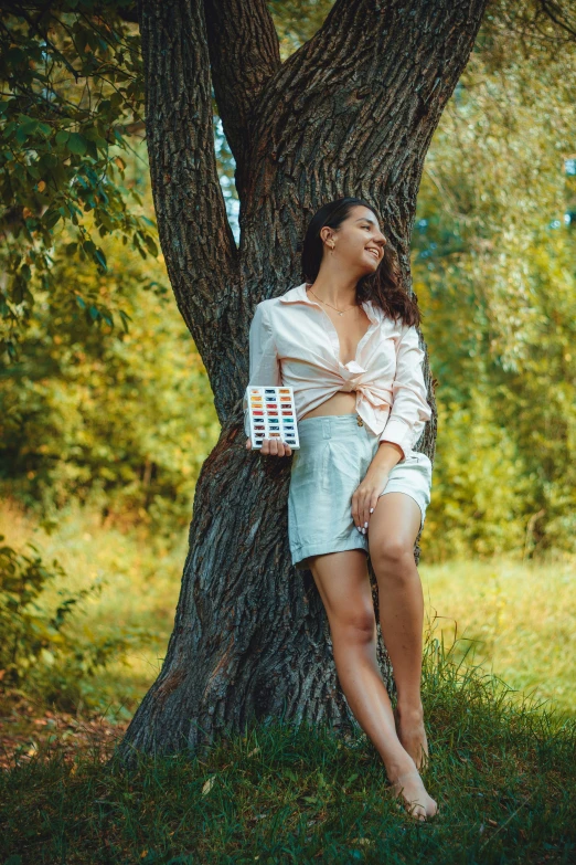 a woman that is laying down by a tree