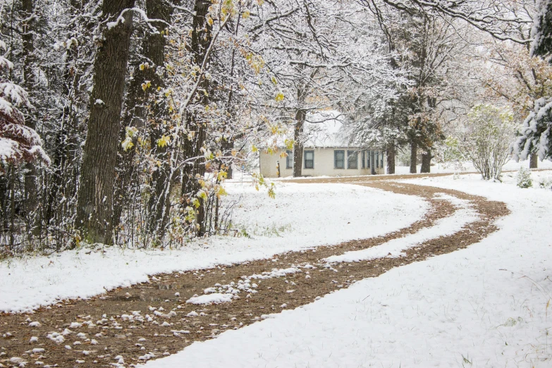 the road in front of this house is covered in snow