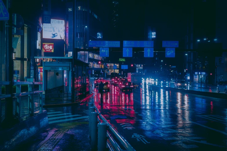 people walking on a street at night in the rain