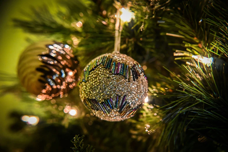 some ornaments are on a green christmas tree