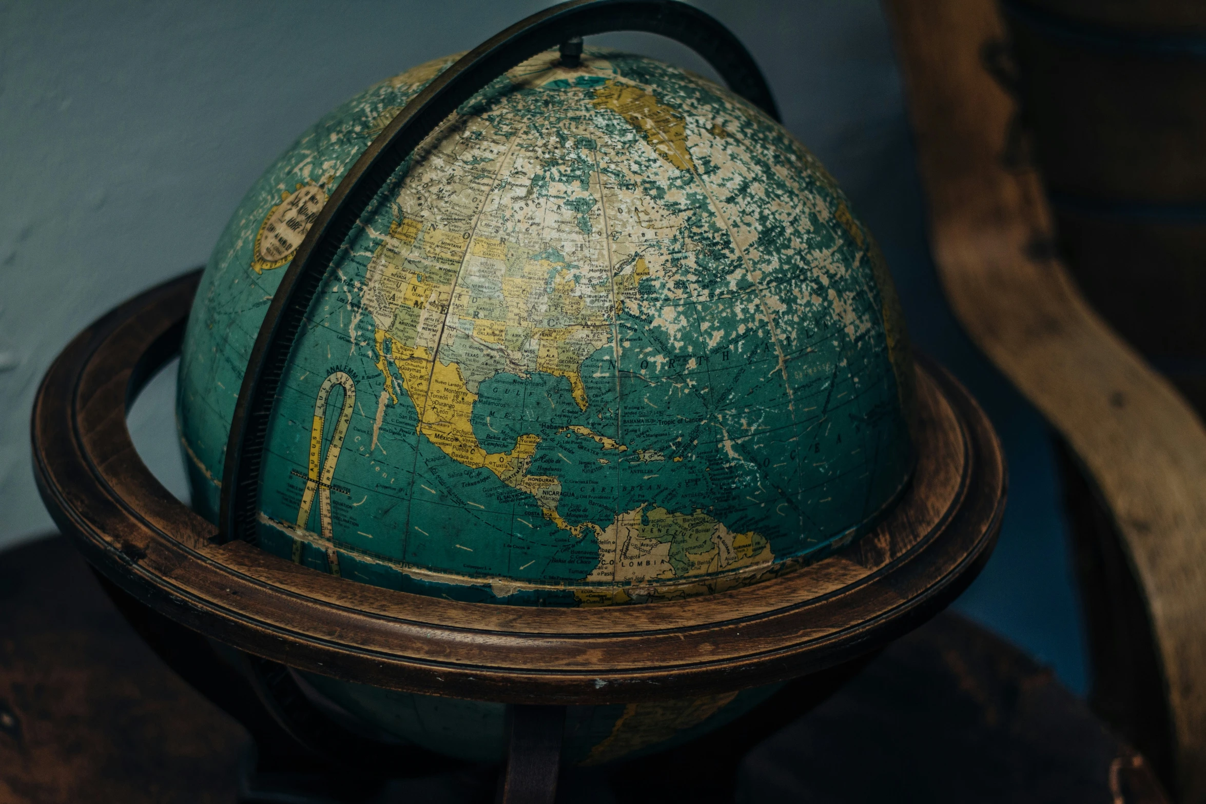 an old globe sitting on top of a wooden stand