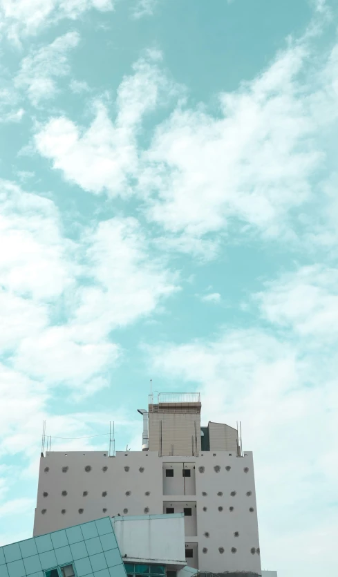 blue and white building in the sky with a few clouds