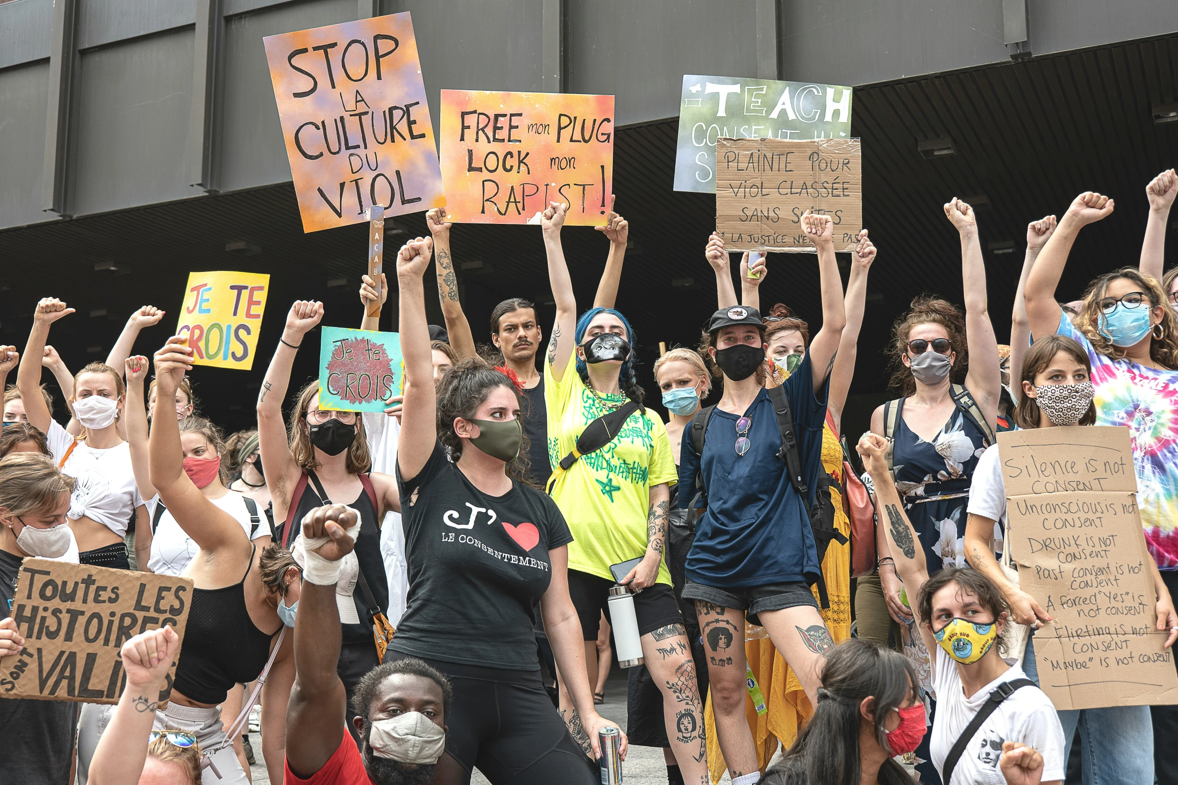 a group of people hold up signs and protest