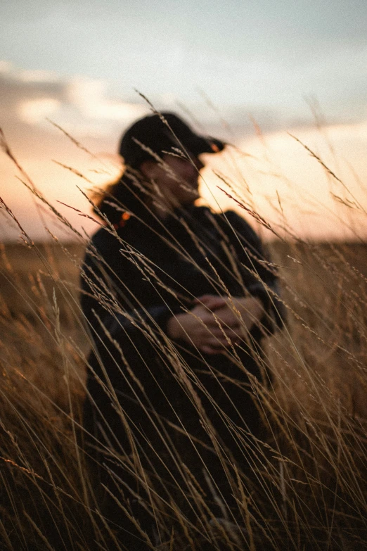 a couple is hugging in tall brown grass