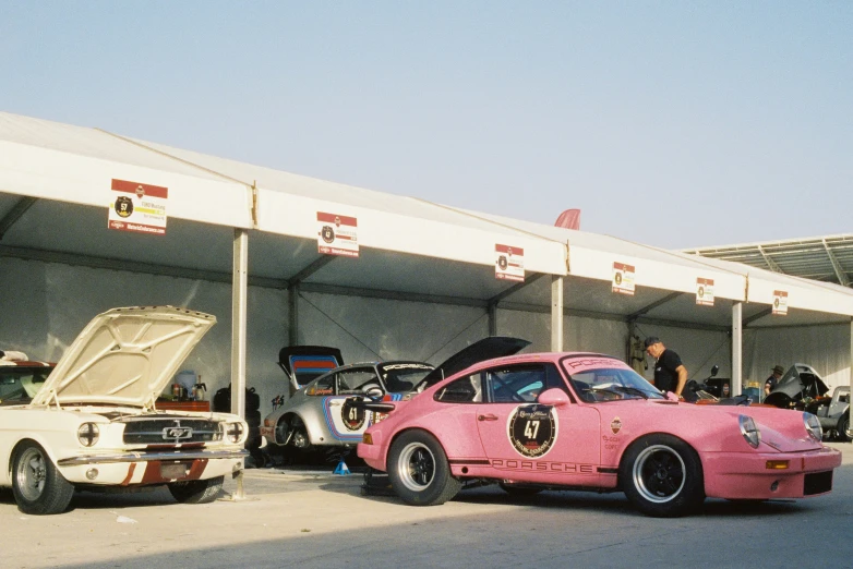 two cars are sitting in front of a car show