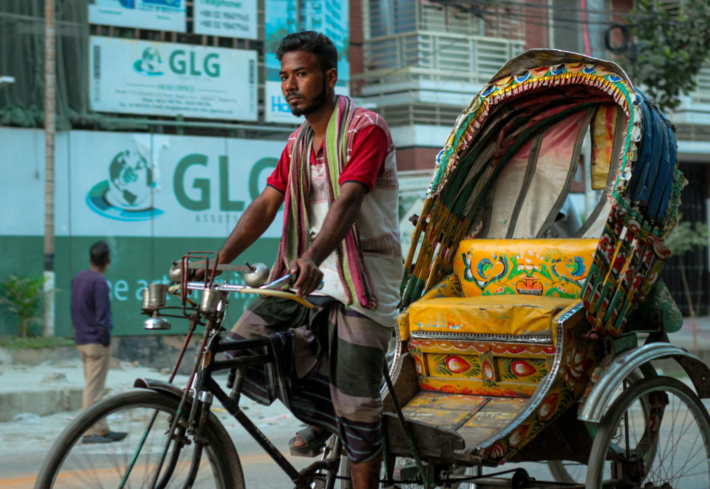 a man standing by his bike while pulling a rickshaw