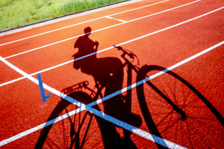 a man is riding his bike on an orange running track