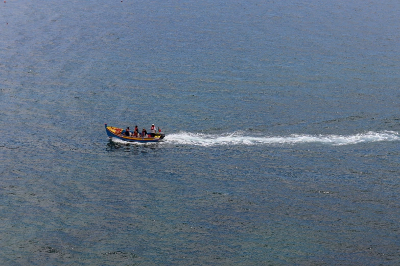 several people riding in a boat while the water is calm