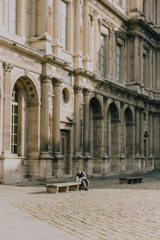 a man sitting on a bench outside a building