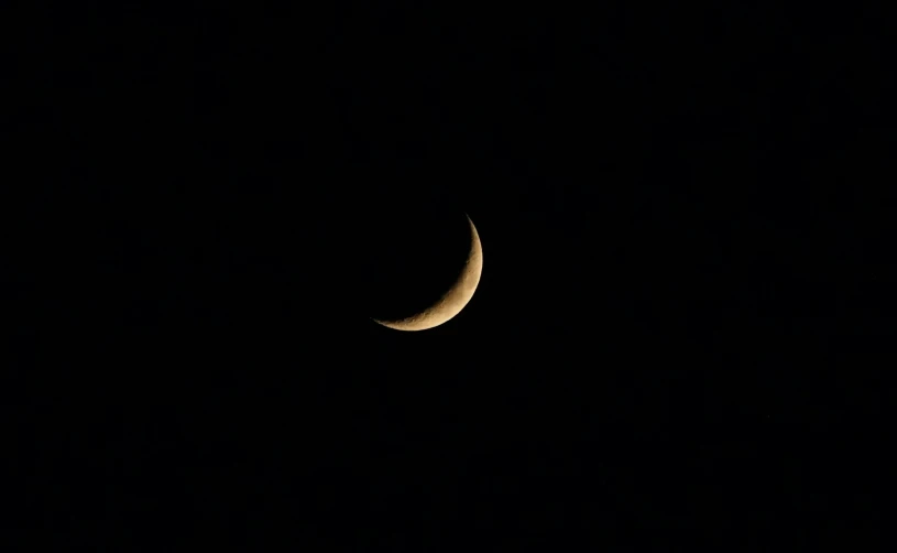 a half moon in the night sky with a black background