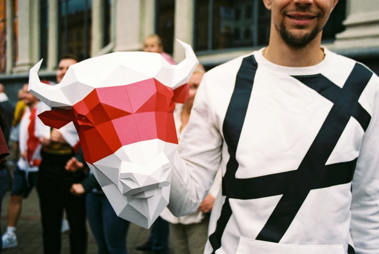 man wearing bull mask with other people in background