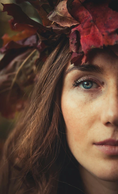 a woman wearing an artistic crown of leaves and eyes