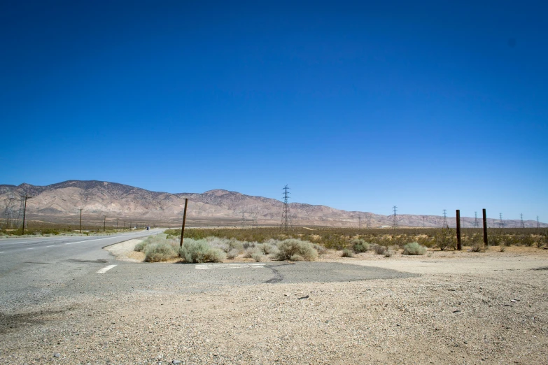 a road in the middle of a desert with mountains in the background