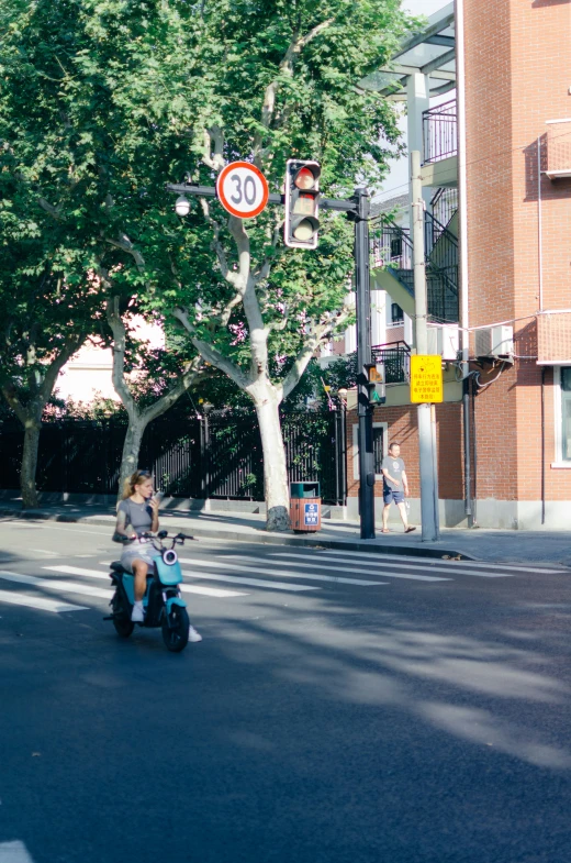 small child with baby carrier going past street sign