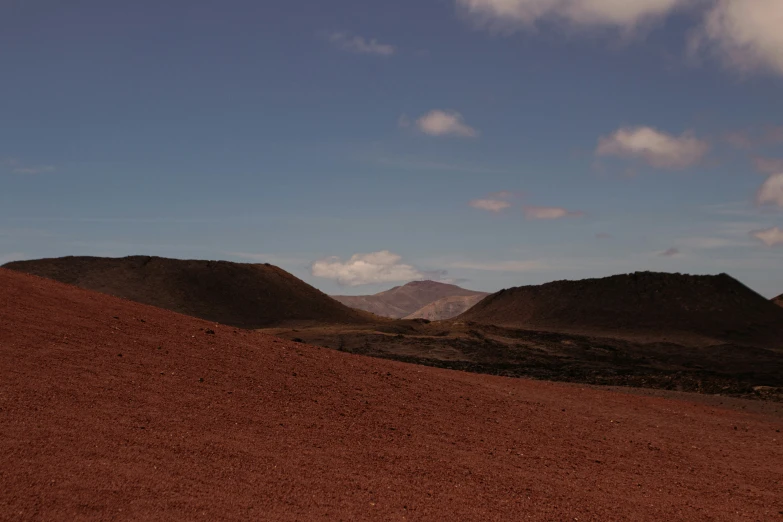 hills of clay against a sky with clouds