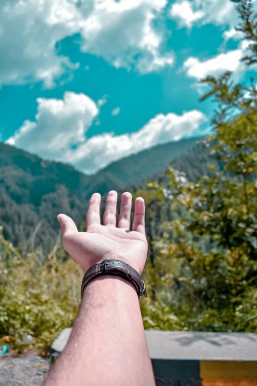 a person reaching for the sky with their hand