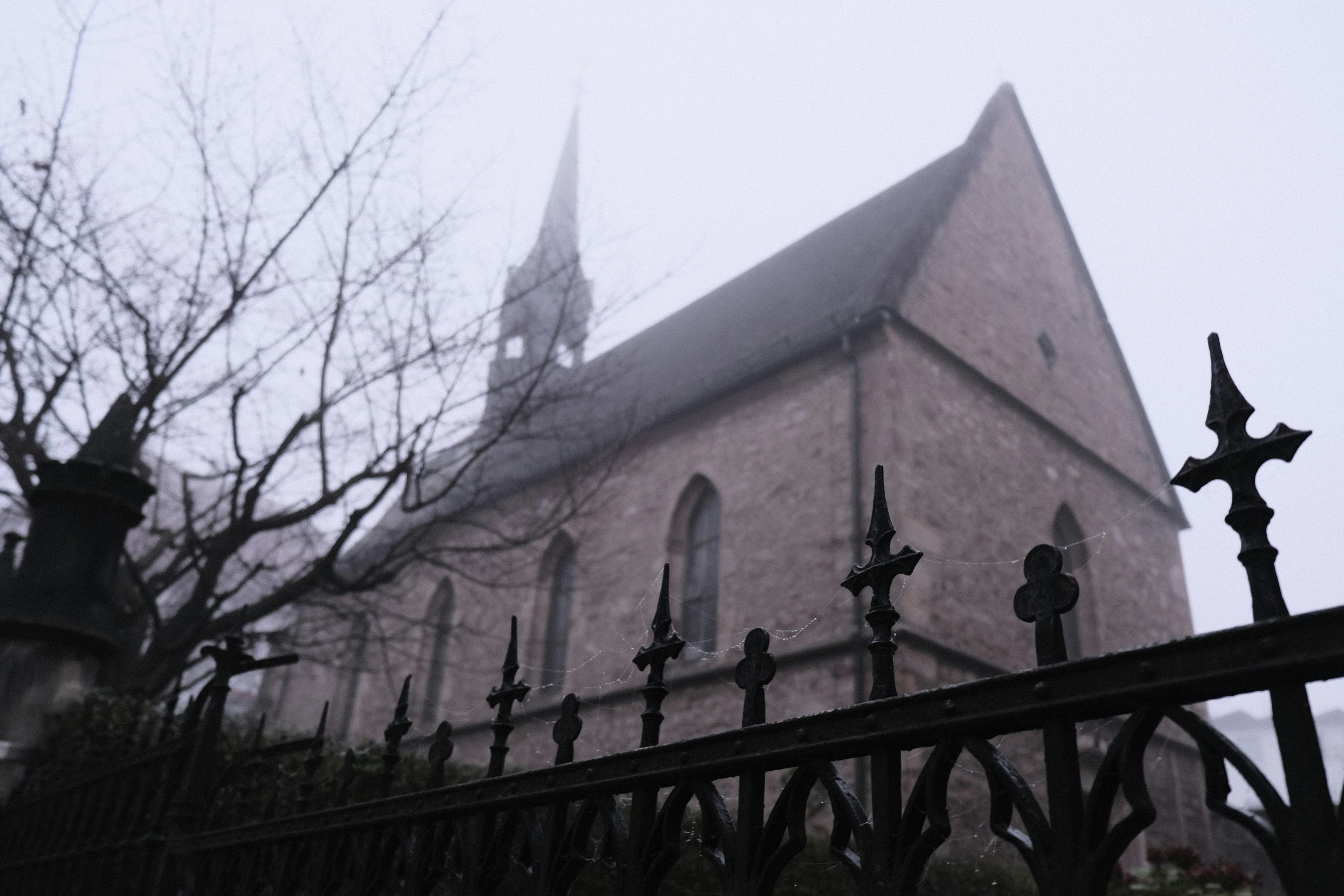 an old, gothic church with an iron fence and gate