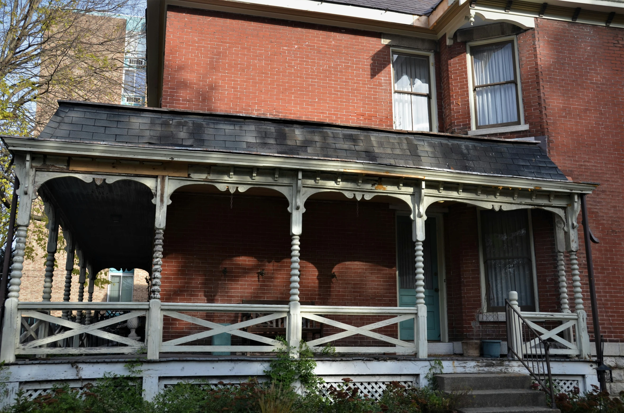 an older house has red brick and white pillars