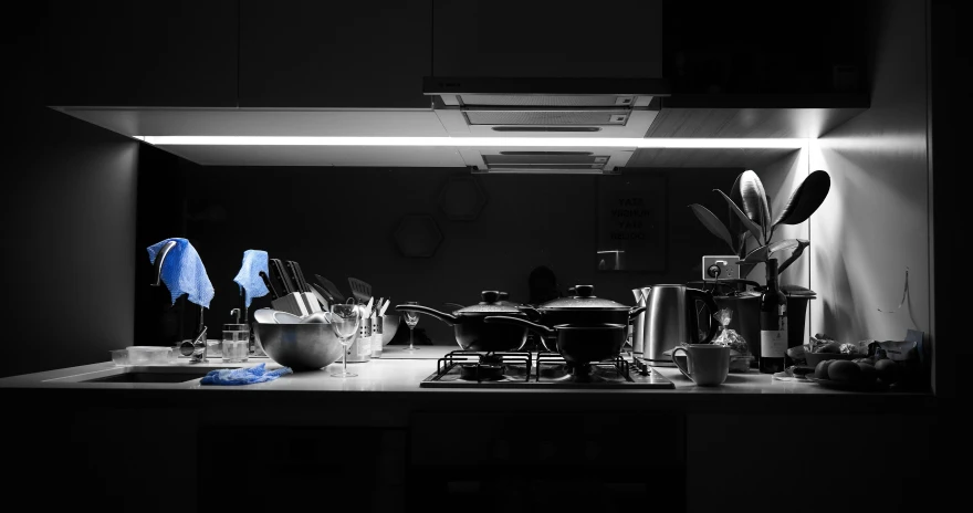 a kitchen counter topped with lots of pots and pans