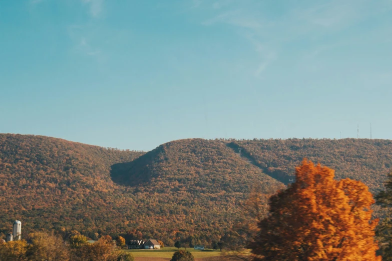 some trees and mountains and buildings with houses in the distance