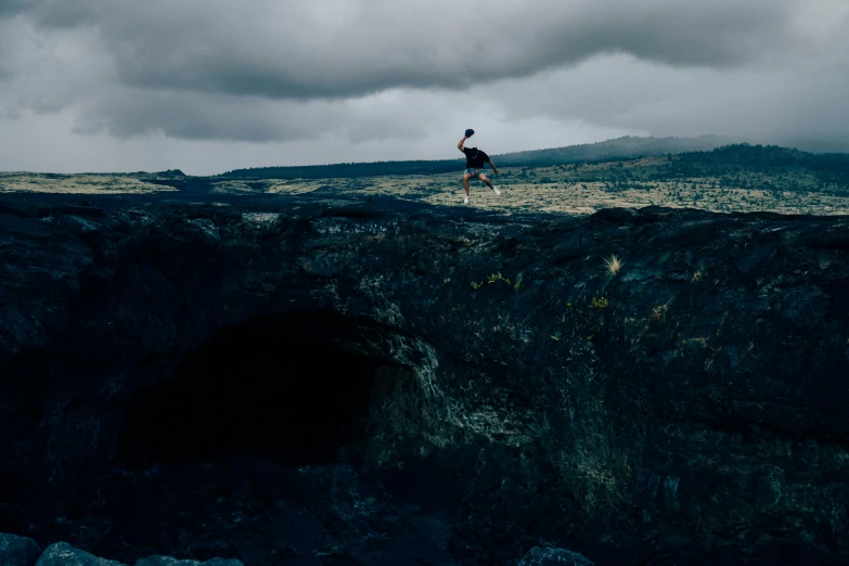 a man standing on a mountain above an ocean