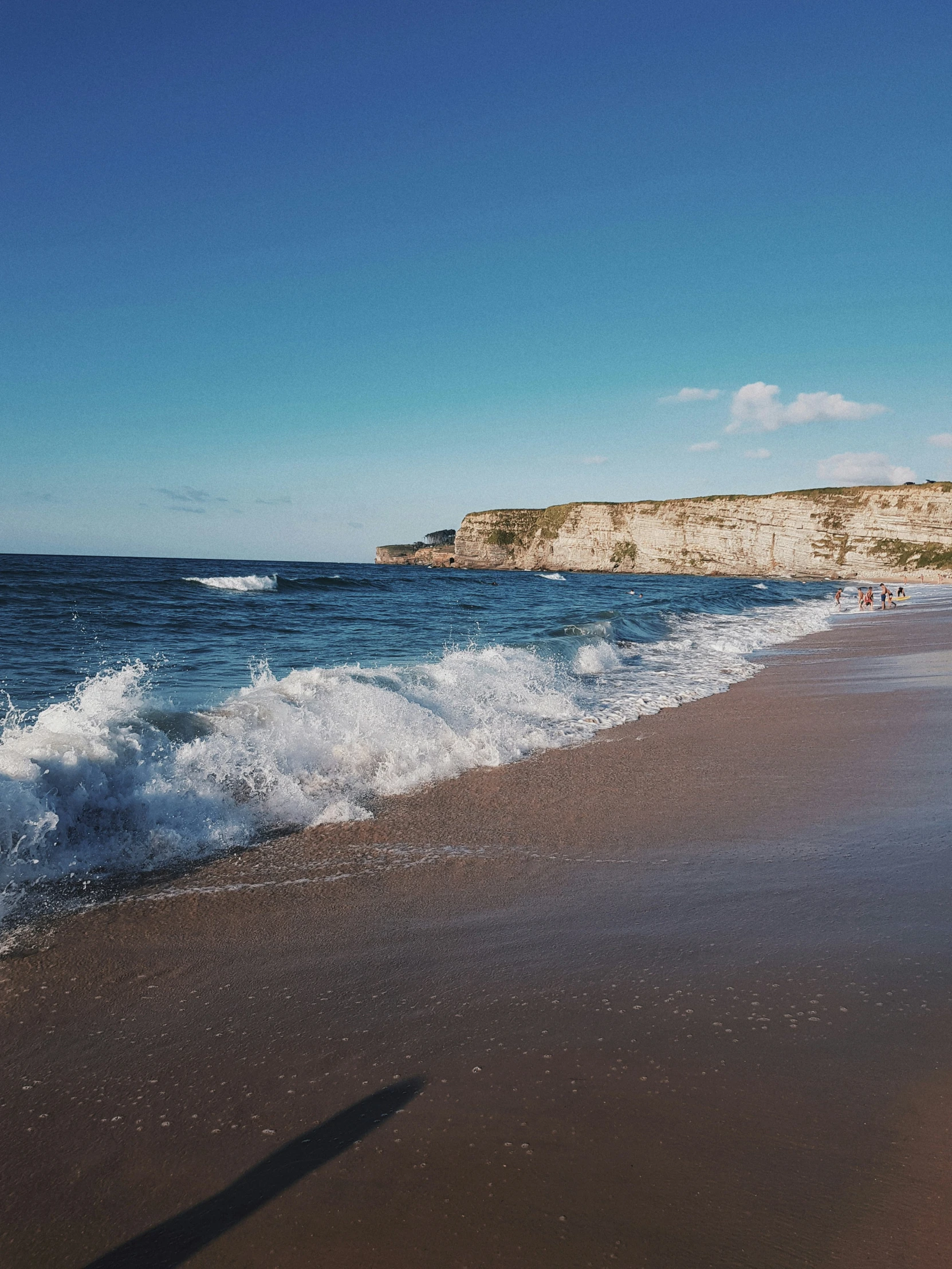 the ocean waves on the sand next to an island