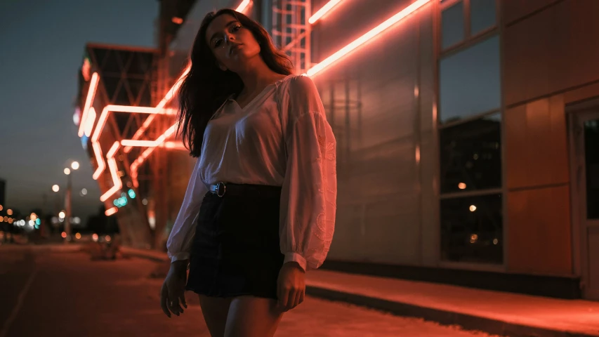 a woman stands on the street looking upwards at soing behind her