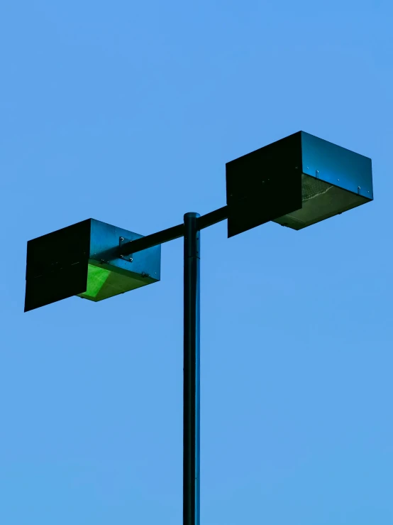 a green light is hanging over the top of a pole