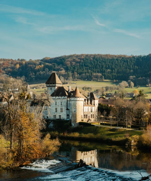 castle with water coming out of it next to trees