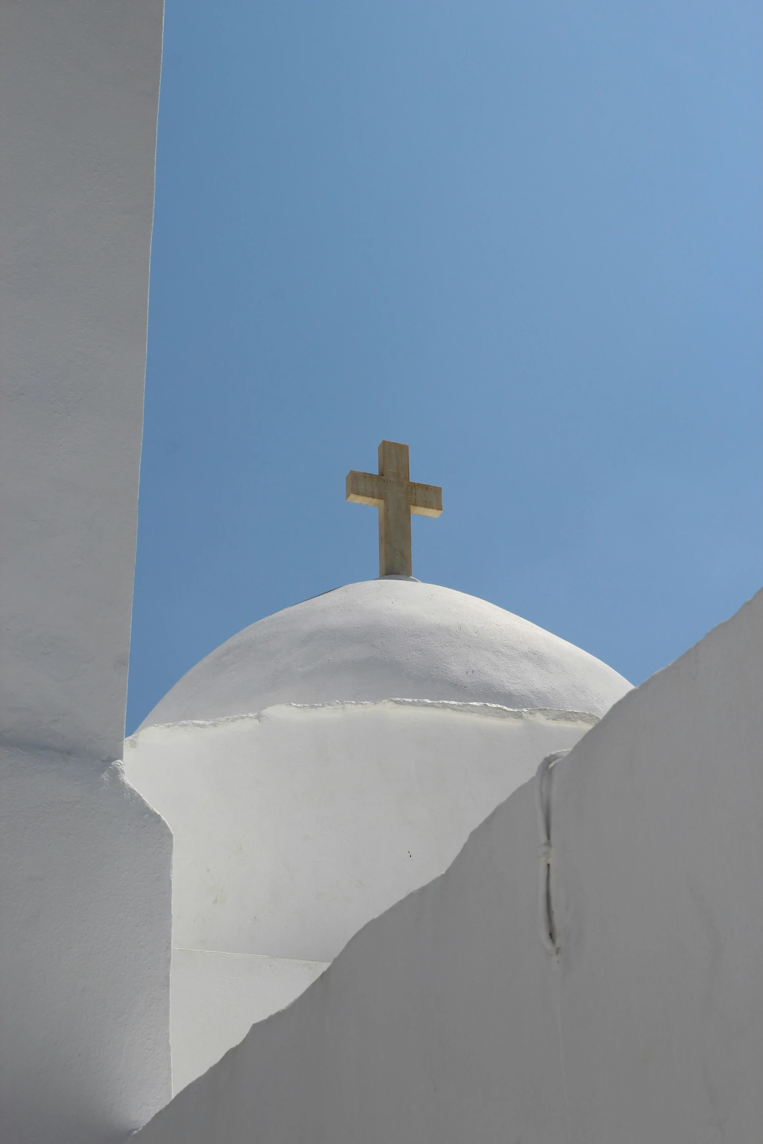 a large cross on top of a white building