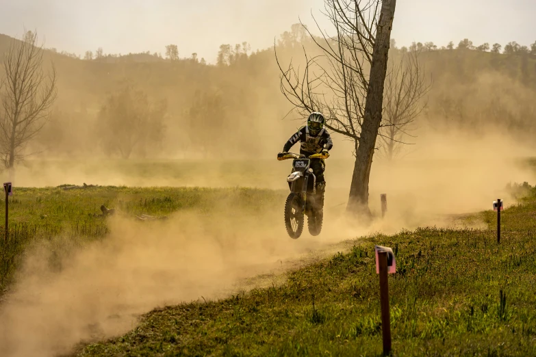 motorcycle rider kicking up dirt as it goes around the corner