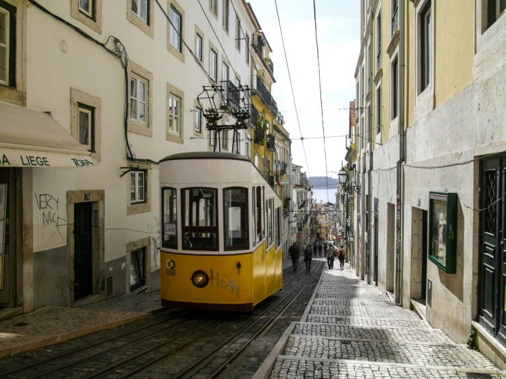 an electric trolley driving down a narrow street