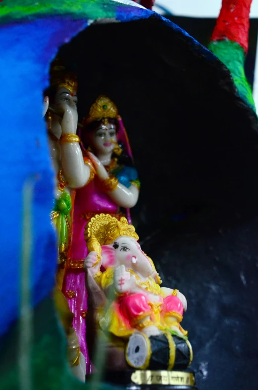 a little figurine of an indian girl on a trinket in front of a fake rock