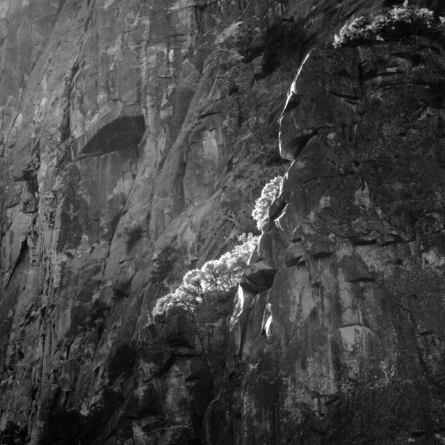 two people hiking up the side of a cliff