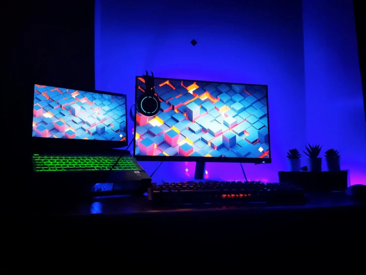 two monitors sitting side by side at night, one is illuminated in the dark