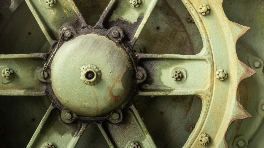 a circular metal structure is painted green and has rivets on it