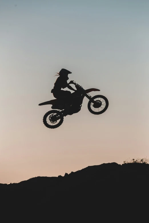 an image of a man riding a motorcycle over the mountains