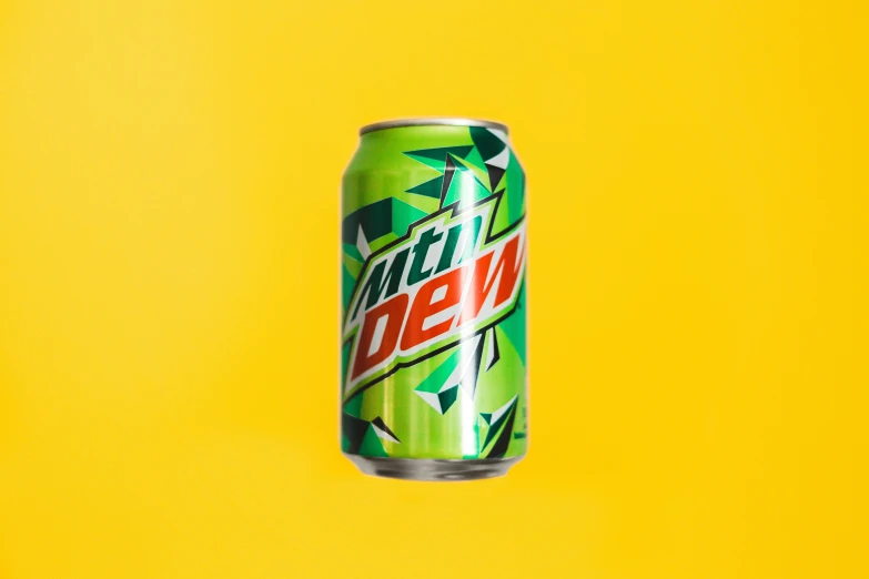 a can of mountain dew against a yellow background