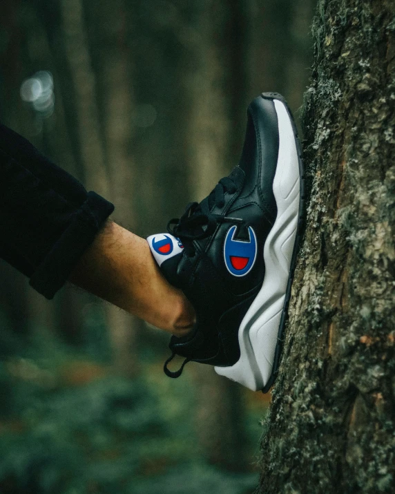 someone is holding their sneakers against a tree