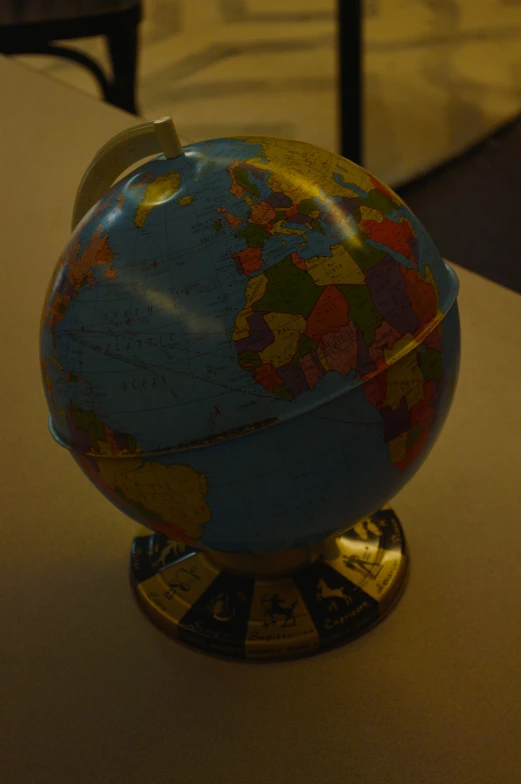 the blue and yellow globe has been placed on a table